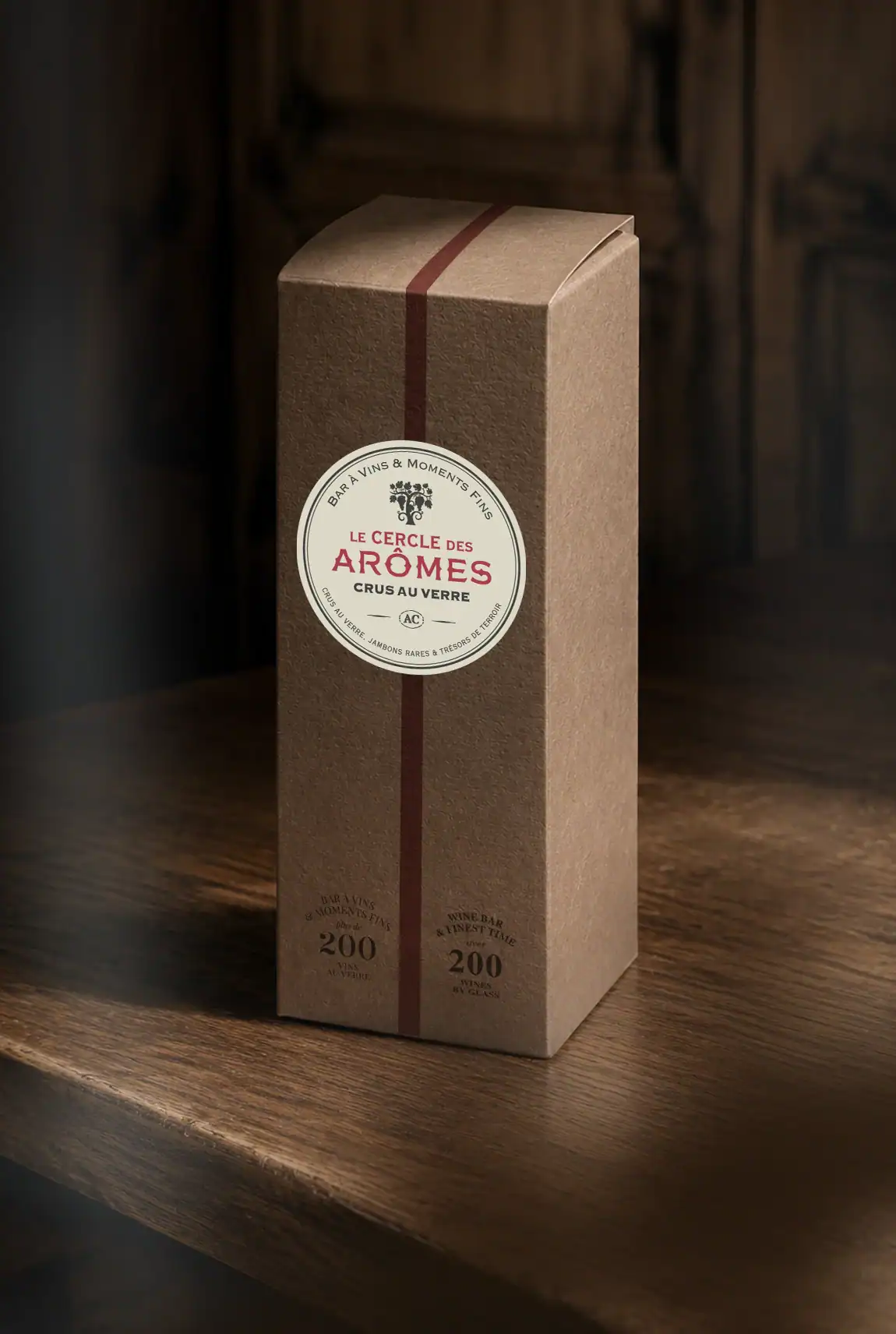 Packaging de bouteille du Cercle des Arômes en carton brun avec bande bordeaux et logotype.