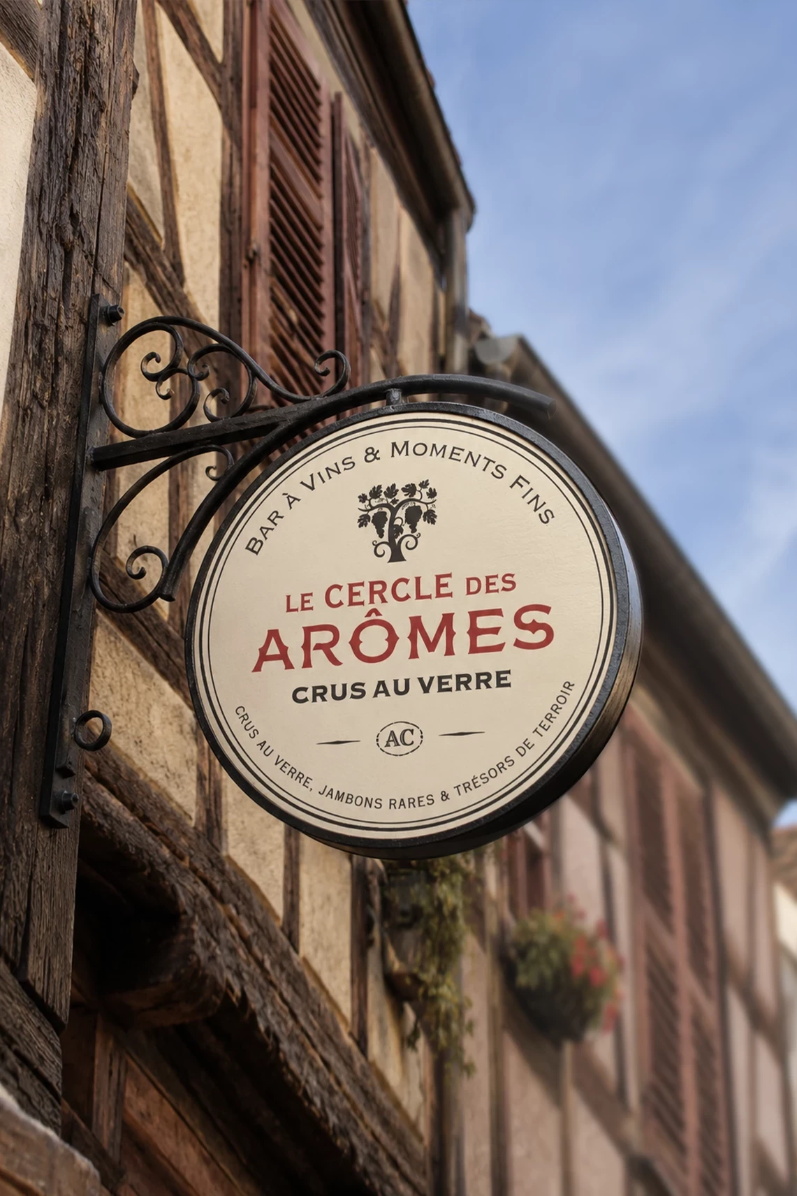 Enseigne ronde du Cercle des Ar&ocirc;mes sur une fa&ccedil;ade ancienne &agrave; colombages de Colmar.