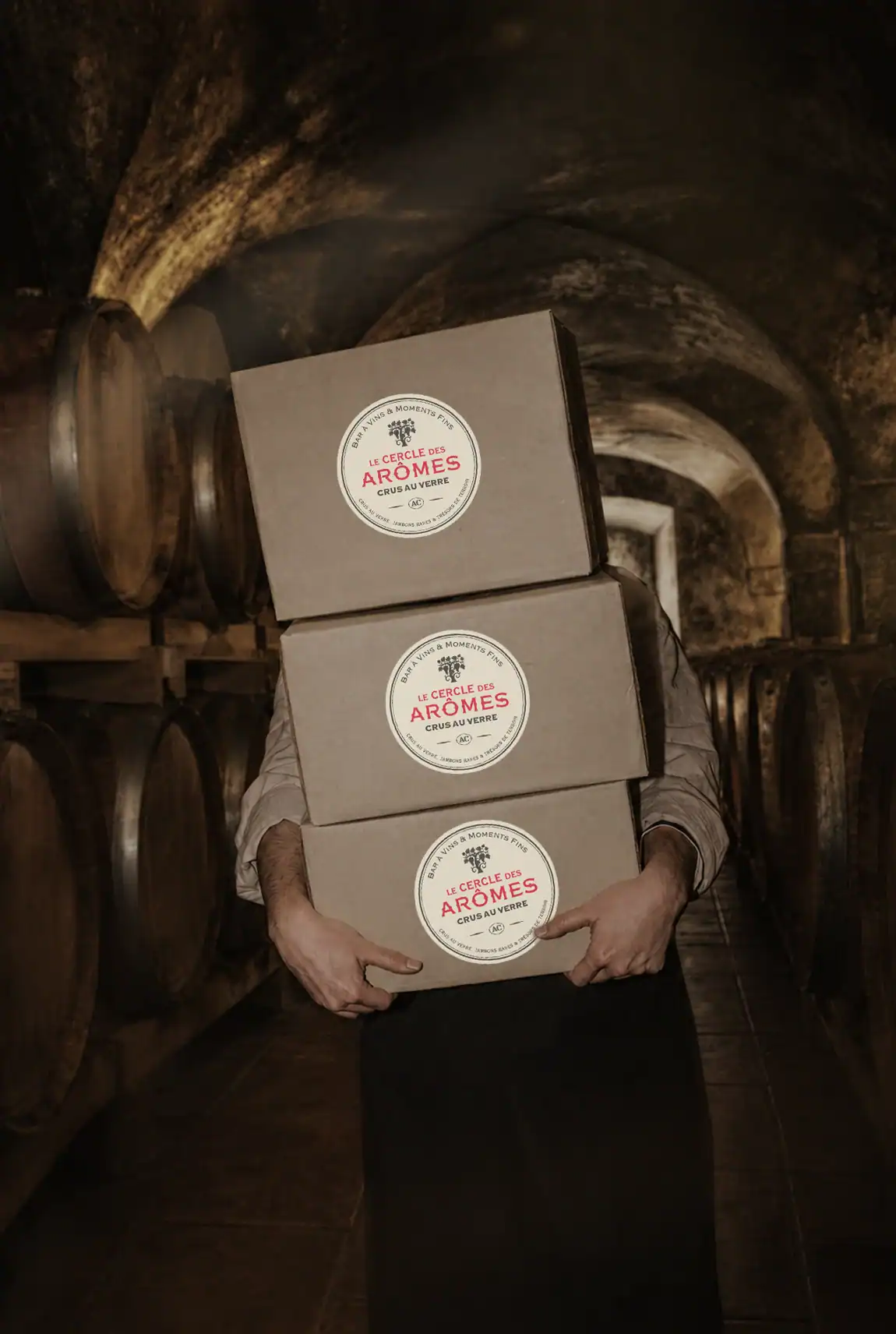 Cartons de vin du Cercle des Ar&ocirc;mes port&eacute;s dans une ancienne cave vo&ucirc;t&eacute;e.
