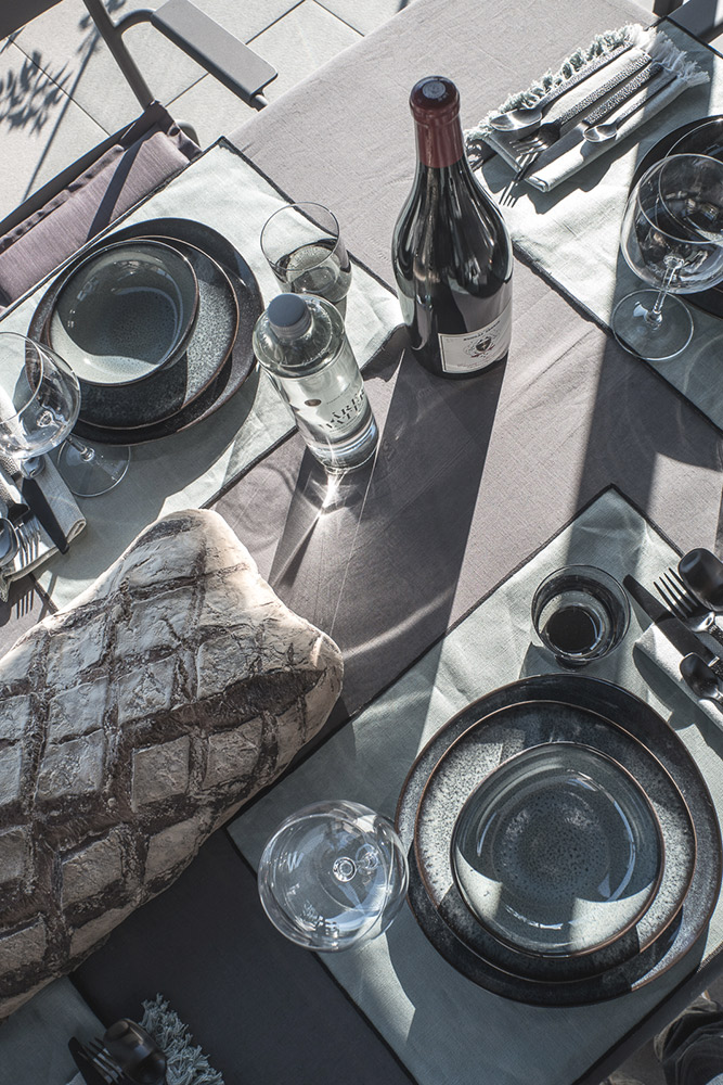 Photographie decoration d'une jolie table en extérieure assiettes émaillées vertes et verre souflés