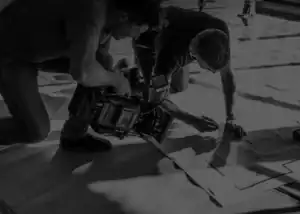 Deux professionnels réalisant un tournage vidéo sur site, capturant des plans précis pour un projet d’entreprise.