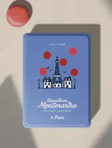 Boîte à macarons de la Biscuiterie de Montmartre, couleur bleu parisien avec motif pois-macaron rouge, logo manuscrit familial et illustration de la tour Eiffel.