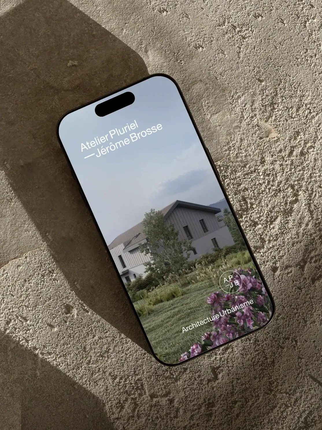 Version mobile du site Atelier Pluriel présentant un projet d’architecture intégré dans un paysage végétalisé