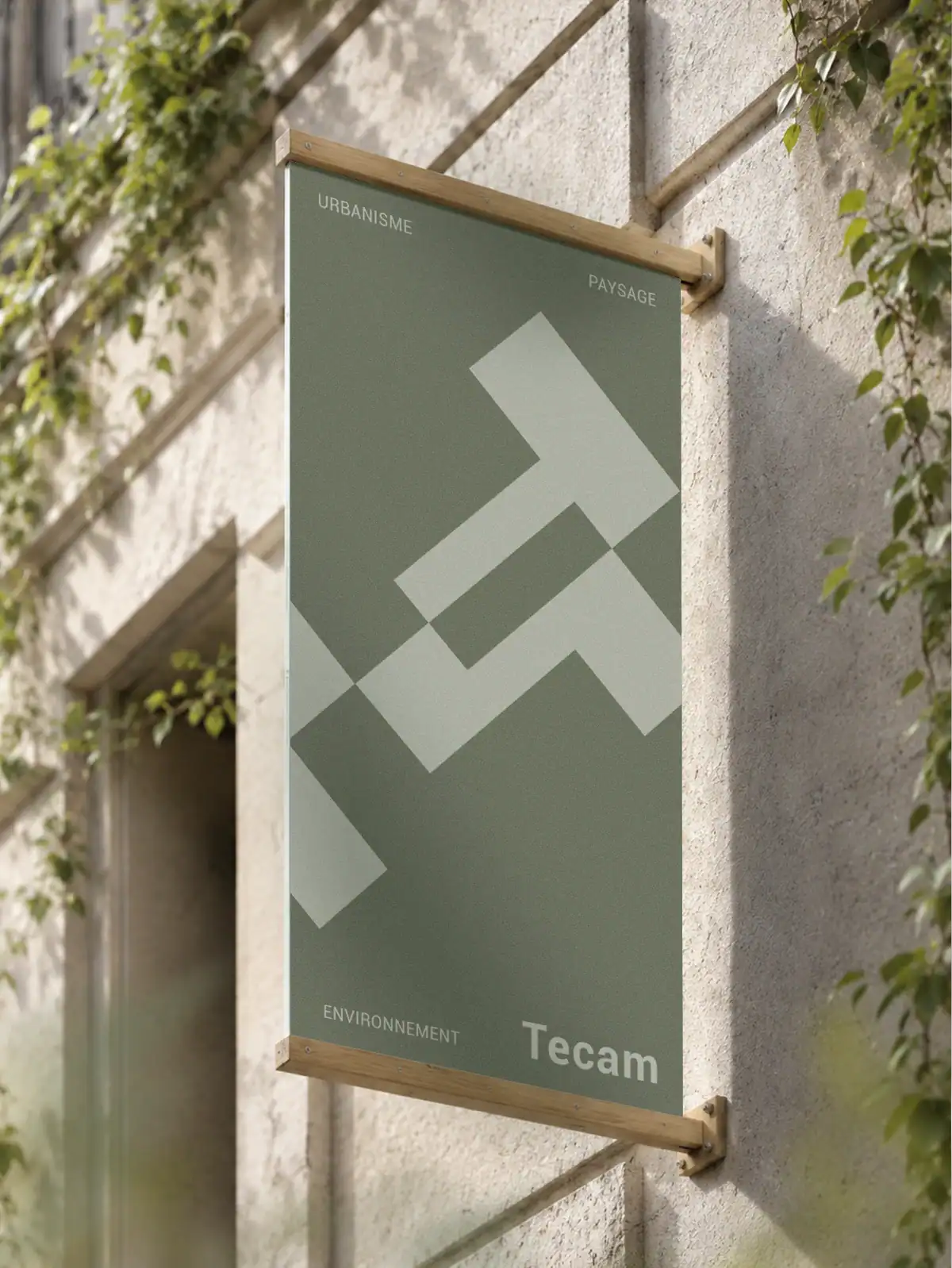 Enseigne ext&eacute;rieure Tecam en bois clair pr&eacute;sentant l&rsquo;identit&eacute; visuelle du bureau d&rsquo;&eacute;tudes en urbanisme, paysage et environnement.
