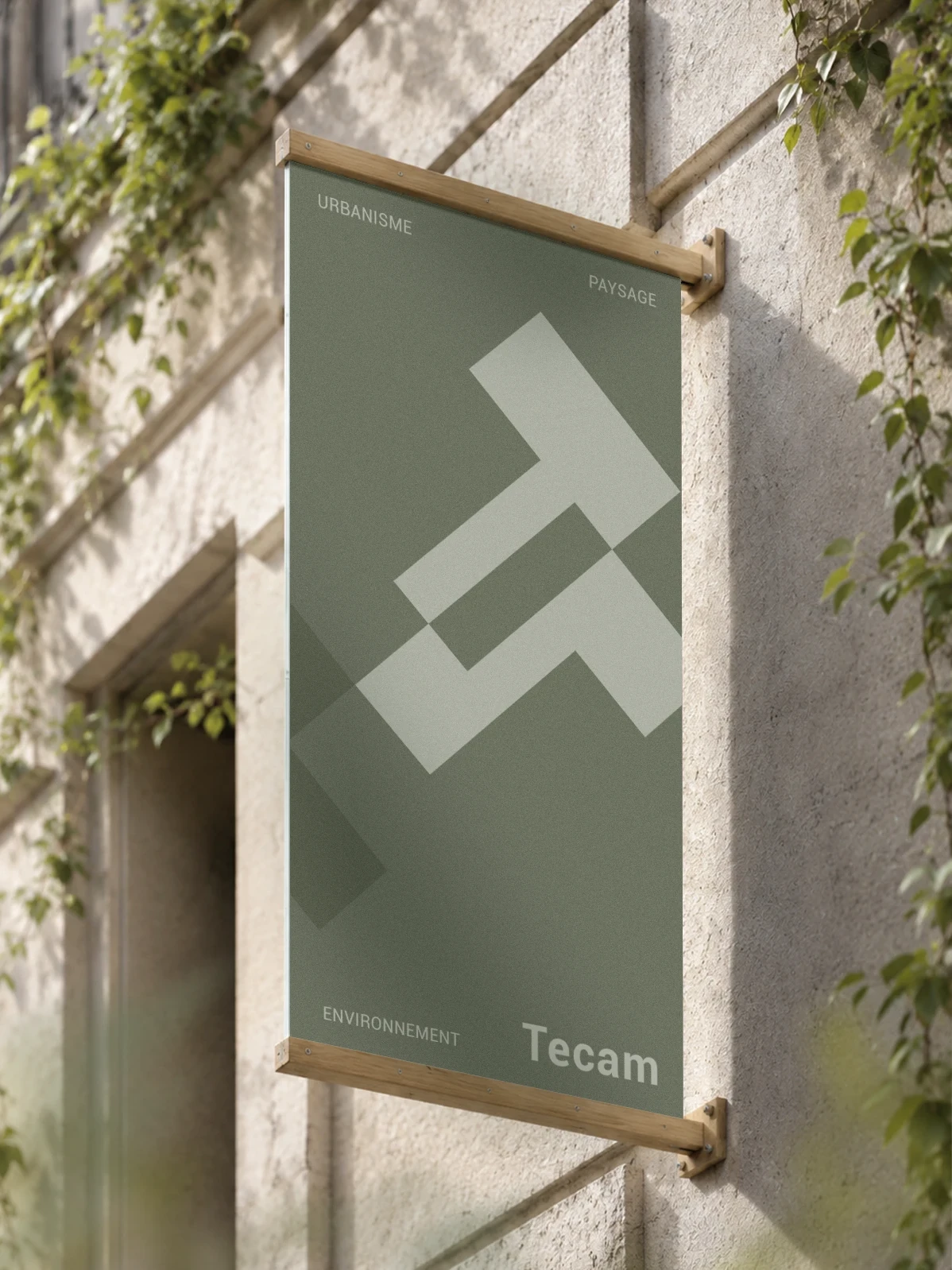Enseigne extérieure Tecam en bois clair présentant l’identité visuelle du bureau d’études en urbanisme, paysage et environnement.