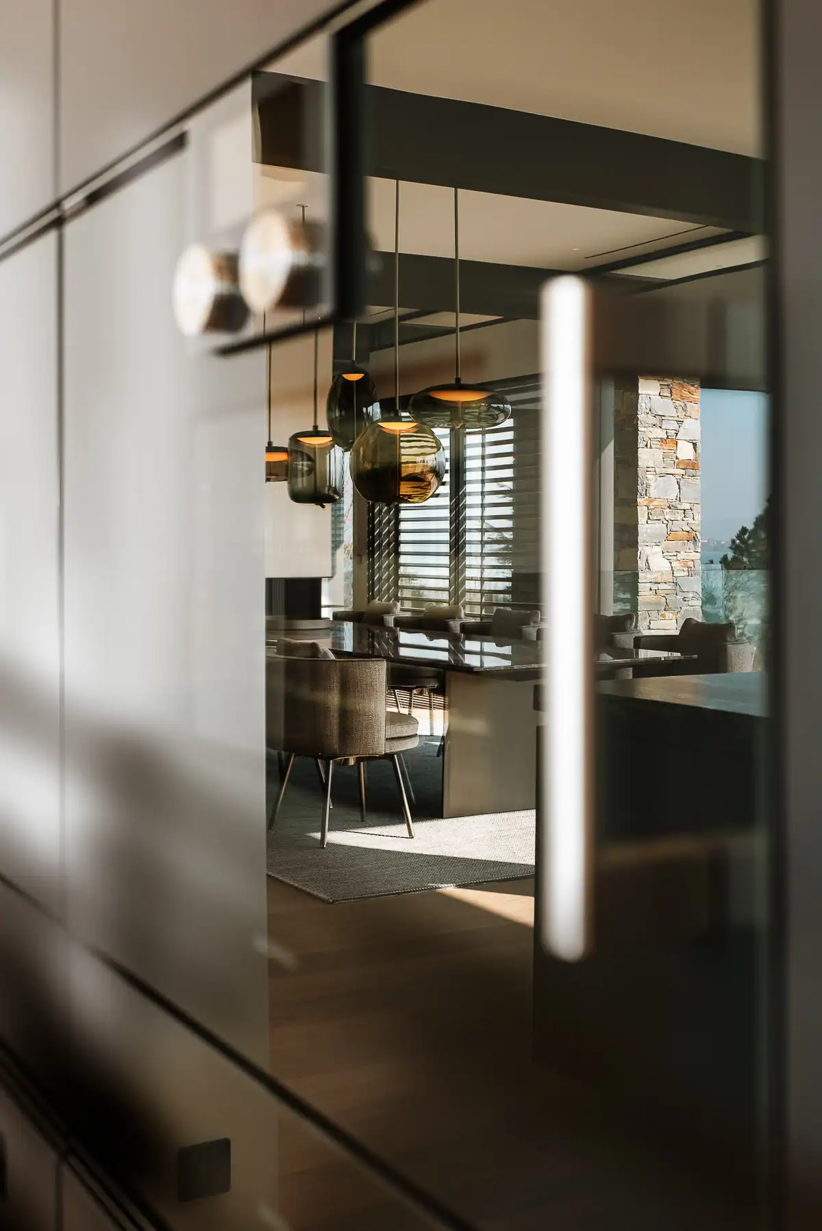 Salle à manger contemporaine photographiée à travers des reflets dans une villa à Genève