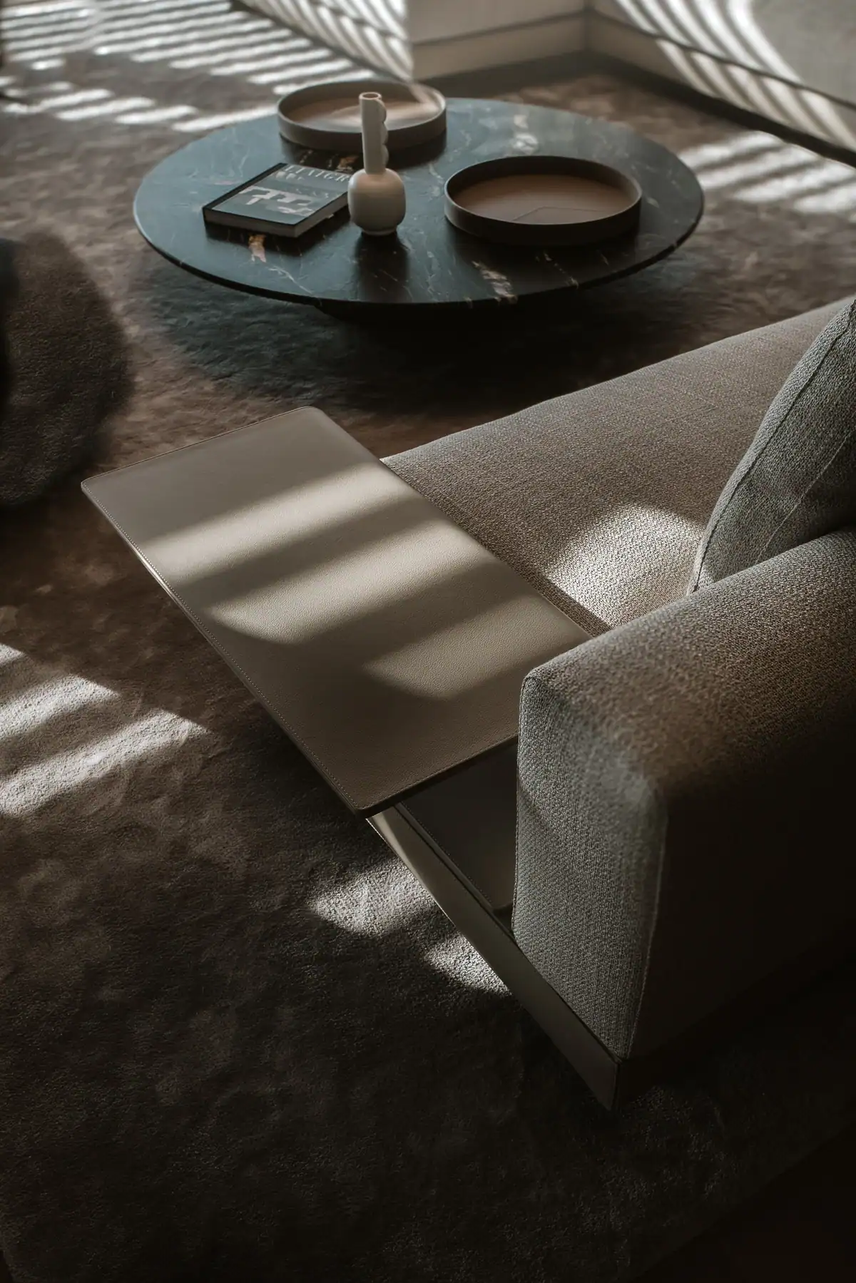 Détail de canapé contemporain, cuir et table basse en pierre dans une villa à Genève