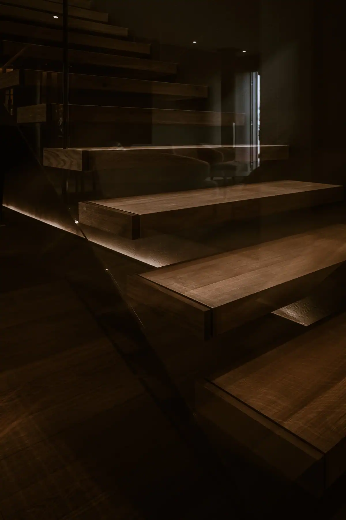 Escalier suspendu en bois avec garde-corps vitré dans une villa contemporaine à Genève