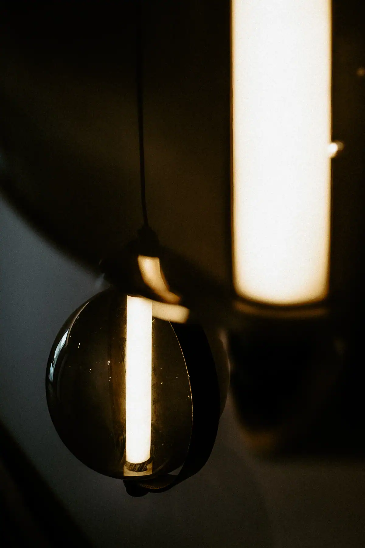 Détail d’un luminaire Brokis en verre fumé avec source lumineuse intégrée