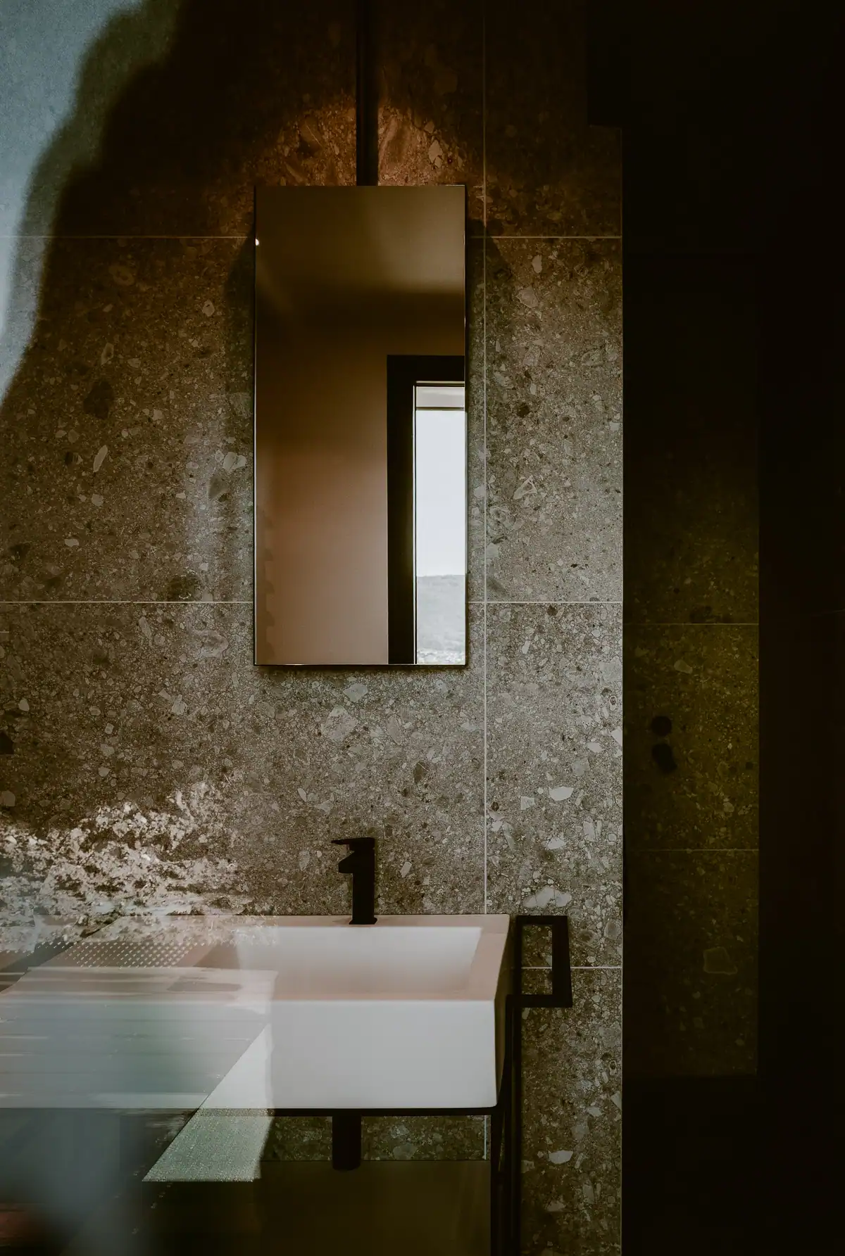 Salle de bains contemporaine avec parement en pierre naturelle et vasque blanche