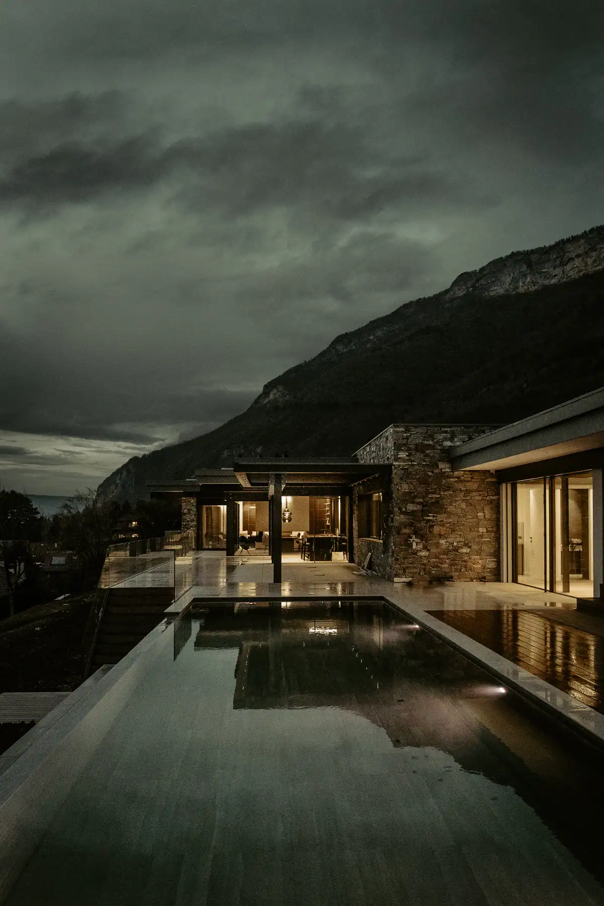 Villa contemporaine proche Genève avec piscine et façades en pierre dans un paysage de montagne