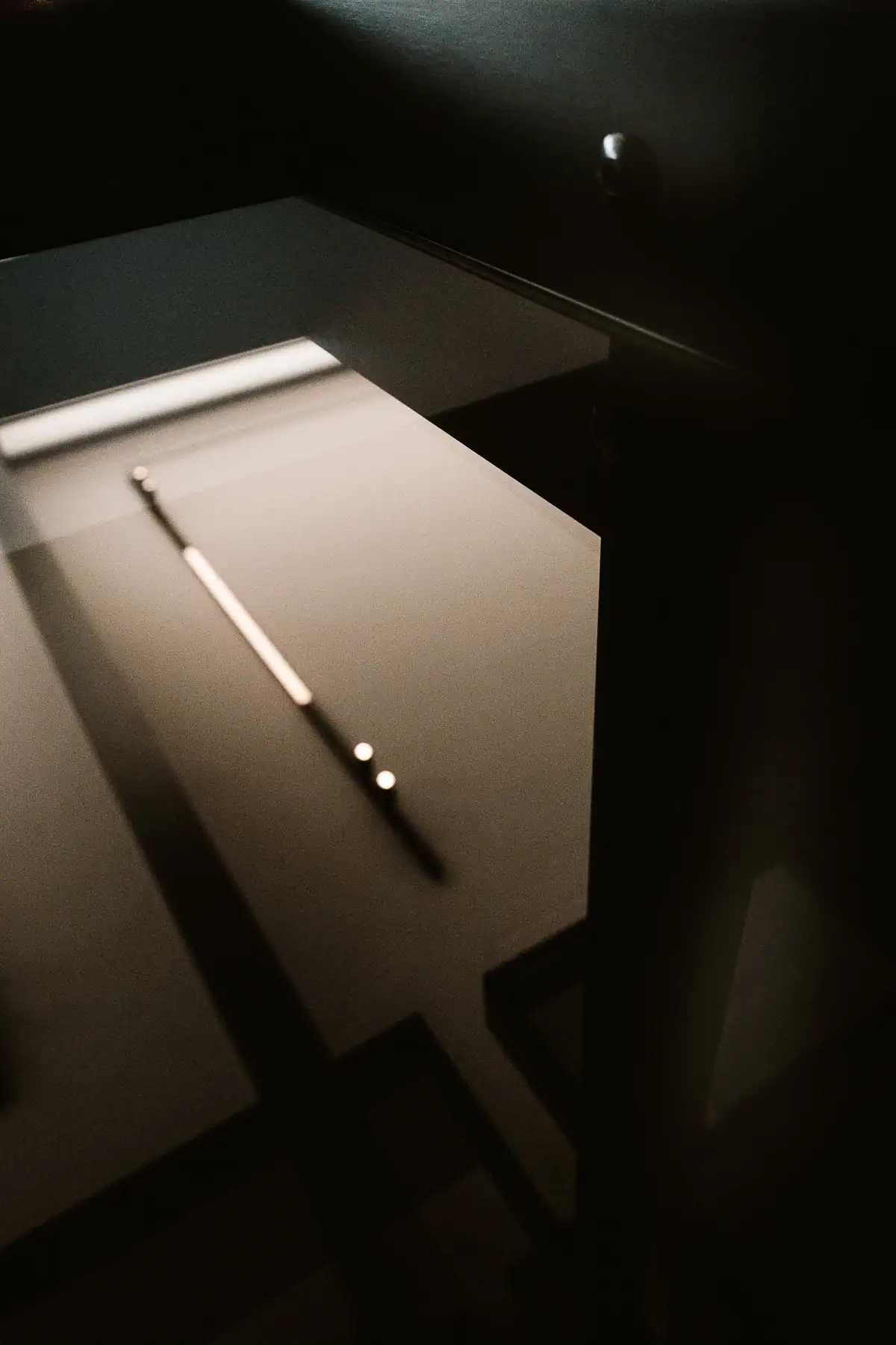Éclairage linéaire minimaliste intégré à un mobilier contemporain sombre