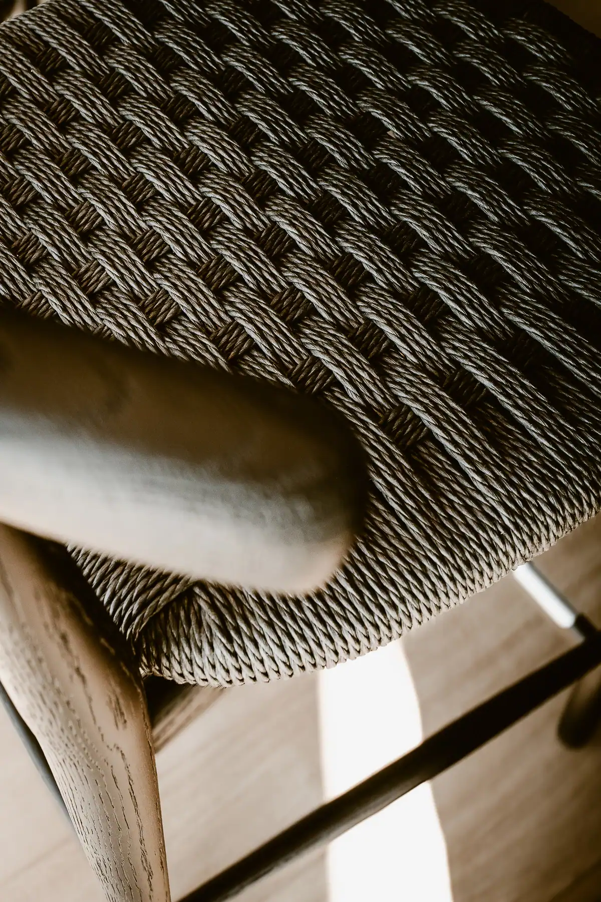 Détail d’une assise tressée Boffi Depadova avec structure en bois dans un intérieur contemporain