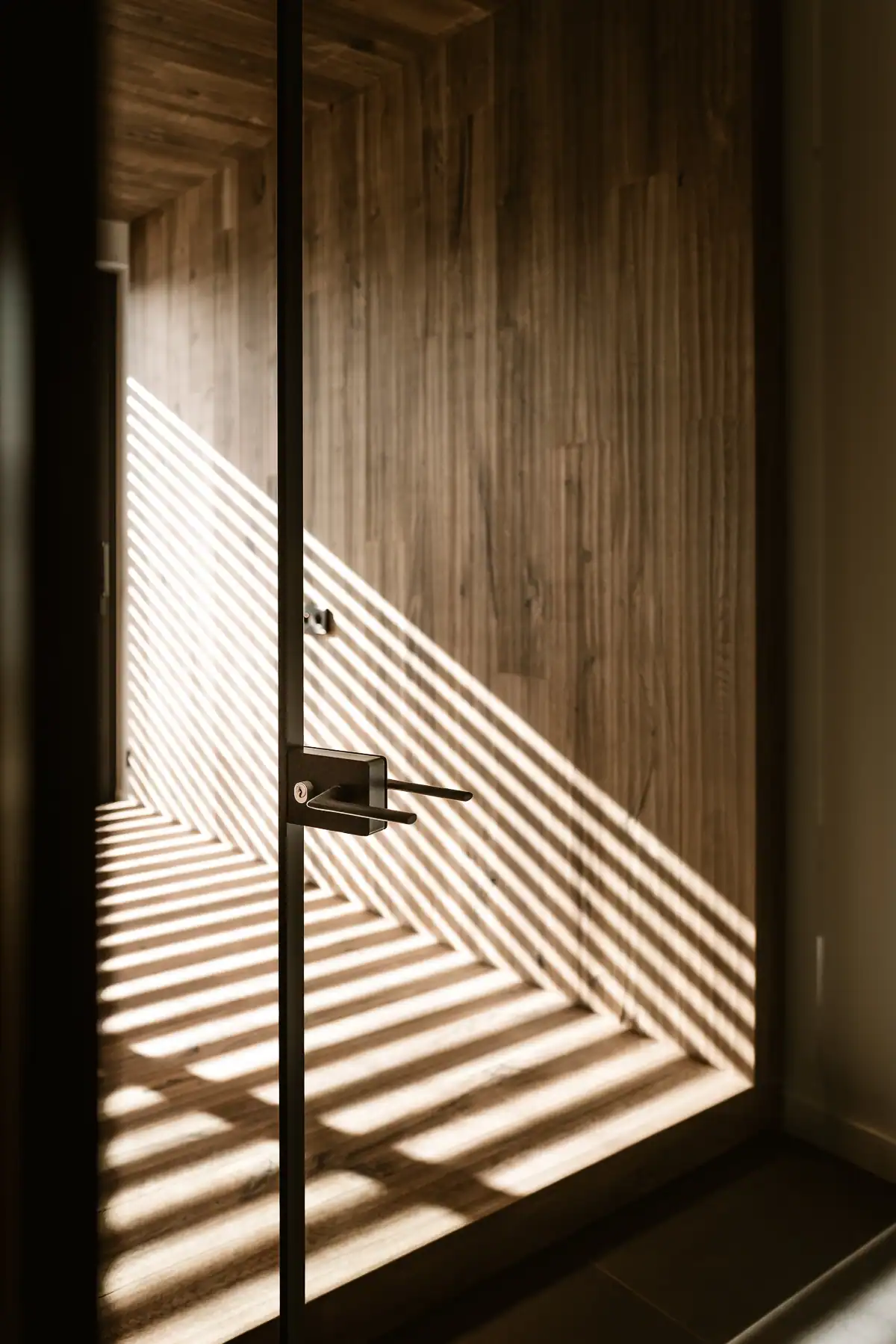 Porte vitrée Rimadesio à cadre noir dans un intérieur contemporain en bois