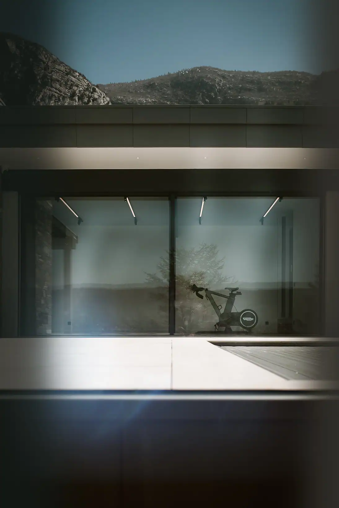 Espace fitness d’une villa contemporaine avec vélo d’entraînement Technogym