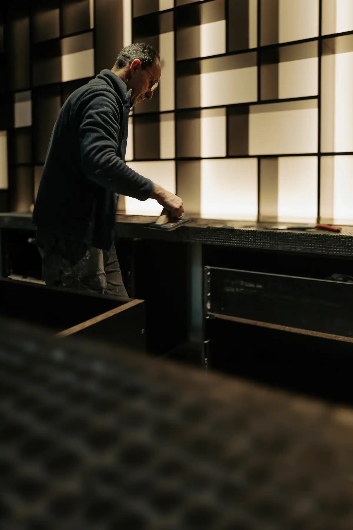 Artisan réalisant les finitions d’un agencement intérieur Rimadesio rétroéclairé