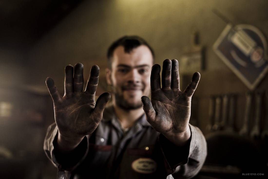 Portrait d’un artisan montrant ses mains marquées par le travail en atelier