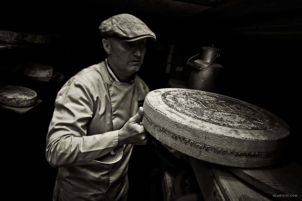 Fromager manipulant une meule dans une cave d’affinage traditionnelle
