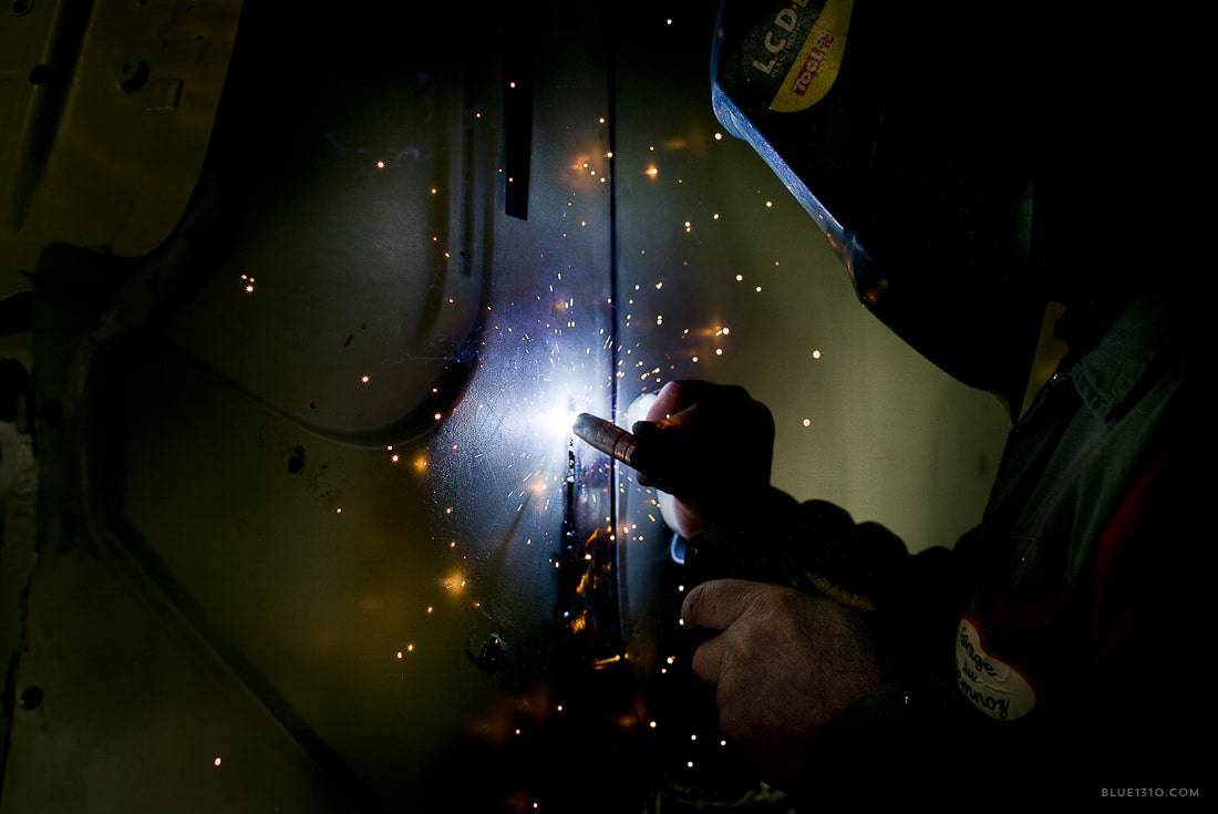 Artisan soudeur travaillant sur une carrosserie de voiture ancienne
