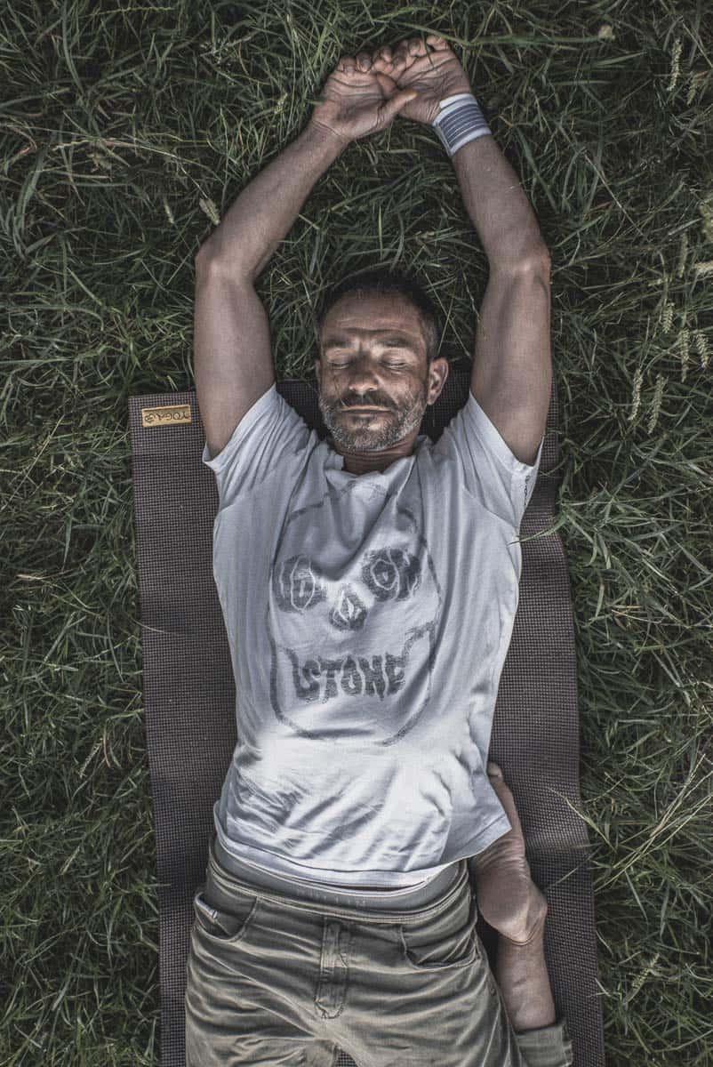 Portrait d’un professeur de yoga allongé dans l’herbe en pleine nature