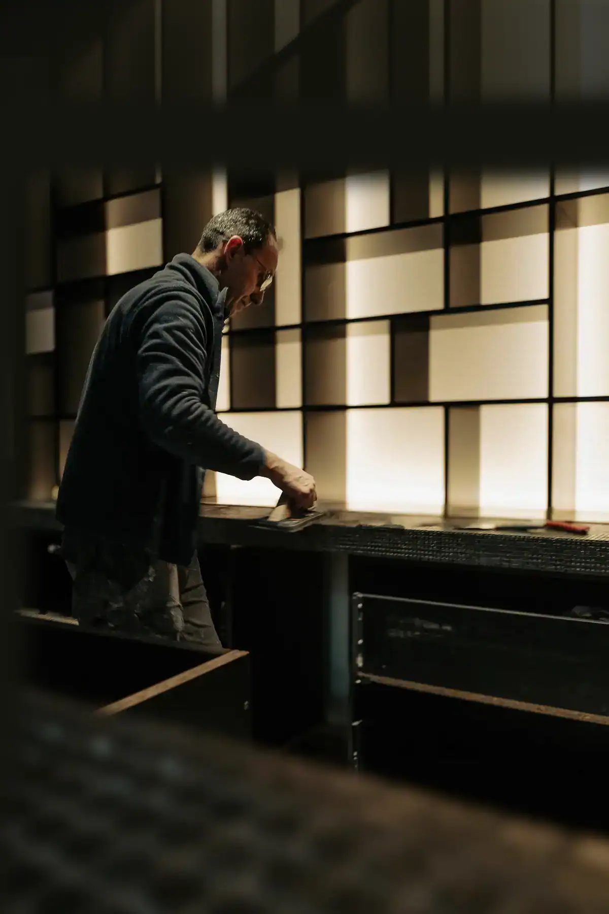 Artisan réalisant les finitions d’un agencement intérieur lors d’un reportage d’entreprise à Genève