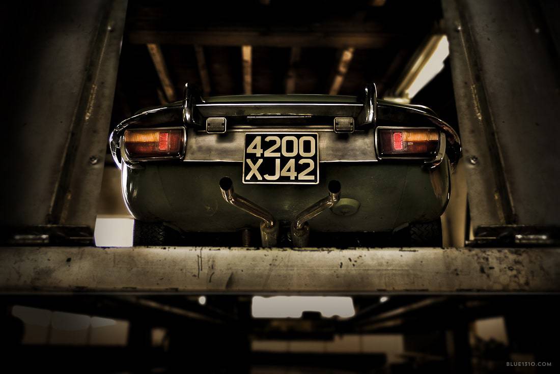 Jaguar Type E en restauration sur un pont élévateur dans un atelier